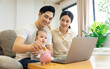© 1112000 - image of asian family with baby sitting on sofa using laptop