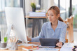 © Tj - Happy young businesswoman Asian siting on the chairs cheerful demeanor raise holding coffee cup smiling looking laptop screen. Making opportunities female working successful in the office.