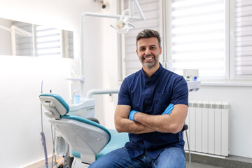 dentist man smiling while standing in dental clinic. portrait of confident a young dentist working i