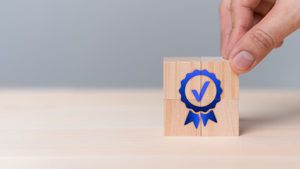 Fototapete - Hand put a quality guarantee sign on wooden cube on table. Service quality assurance, Standards, ISO certification and standardization concept. Advertising product and quality commitment.