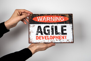 Wall Mural - agile development. warning sign with text in the hands of a woman