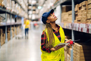 Portrait of smiling african american engineer woman order details checking goods and supplies on shelves with goods background in warehouse.logistic and business export