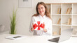© golubovy - Corporate greeting. Excited woman. Unexpected surprise. Happy lady expressing joy holding present box red ribbon sitting desk in light room interior.