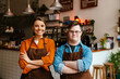 © Drobot Dean - Man with down syndrome and his female colleague smiling while standing in cafe with arms folded