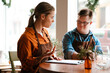 © Drobot Dean - Woman training man with down syndrome to work in cafe while sitting at table