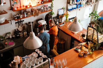 Wall Mural - Woman training man with down syndrome to work as barista in coffee shop