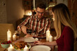 © Stockphotodirectors - Beautiful couple having romantic dinner with candles and red wine at home