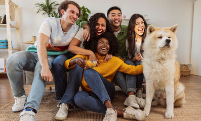 Wall Mural - group of young millennial girls on sofa with dog - multiracial people having fun - roommates, students