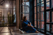 © Stanislava - Beautiful brunette sitting barefoot by the window in the loft