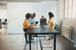 © Flamingo Images - Diverse businesspeople smiling while working together around an office table