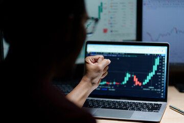 Canvas Print - Successful Businessman Sitting at Desk Using Laptop Computer, Celebrate Success. Entrepreneur in Suit working with Stock Market App Smiles, Happy Victory. Motion Blur Background.