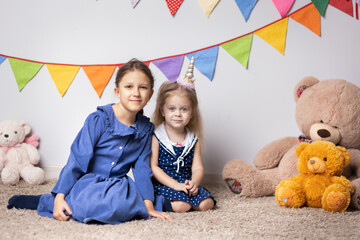 Wall Mural - Two sisters are sitting on a carpet