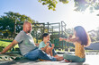© Caia Image - Father and children sitting on trampoline in sunny backyard