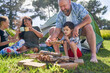 © Caia Image - Father and son with Down Syndrome stacking firewood at campsite
