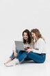 © wedmoments.stock - Young happy couple of young women on white background communicate showing laptop together. Chroma Key