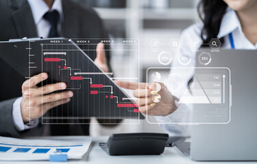 Business team hand Project manager working and update tasks and Gantt chart scheduling virtual diagram.with smart phone, tablet and laptop in office.