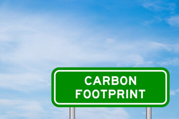 Green color transportation sign with word carbon footprint on blue sky with white cloud background