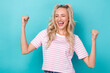 Photo of young astonished overjoyed blonde hair girl wear stylish pink t-shirt fists up hooray yelling champion isolated on cyan color background