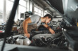 © fotofabrika - Young male mechanic examining engine under hood of car at the repair garage