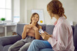 © Studio Romantic - Child attending therapy session with psychologist. Cheerful teenage girl talks to female psychologist talking about positive emotions she felt. Child and the therapist are sitting on sofa in office.