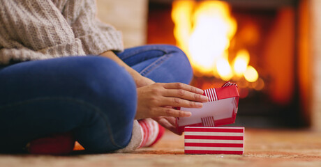 Poster - Someones about to get super happy. a unrecognisable woman opening presents during Christmas at home.