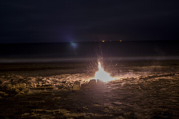 Wall Mural - An exploding firecracker on the sand against the background of the sea