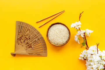 Wall Mural - Bowl of rice and asian fan with cherry blossom branch. Asian concept