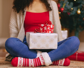 Sticker - Something tells me Santa needed a bigger sleigh this year. a unrecognisable woman opening presents during Christmas at home.