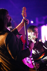 Wall Mural - Band playing music and a gig in a venue, close up of a rock band playing guitars and instruments.