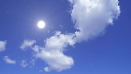 Wall Mural - Bright midday sun and clouds. Moving clouds gliding fast across the skies