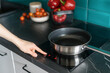© brizmaker - woman prepare dinner on electrical hob at modern kitchen, closeup