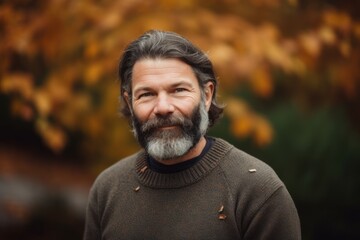 Wall Mural - Portrait of a senior man with grey beard and mustache in the autumn park