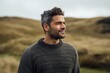 © Robert MEYNER - Portrait of a handsome young man with dark hair and beard in a knitted sweater standing in the countryside