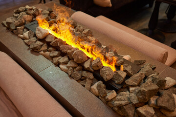 Electric log fireplace. Restaurant showcase decorated with artificial heater. Exterior design.