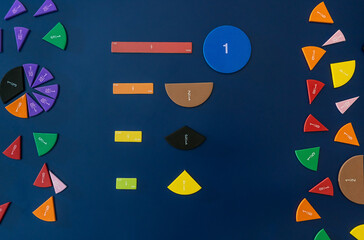 Wall Mural - Math fractions on blue background. Interesting math for kids. Education, back to school concept. Geometry and mathematics materials. Close up