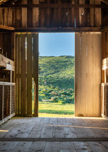 View Of Green Landscape From Inside Doorway Of Rustic Barn