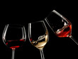 Red, white and rose wine glasses plash on black background