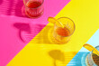 Glasses of rum with orange slices on colorful background