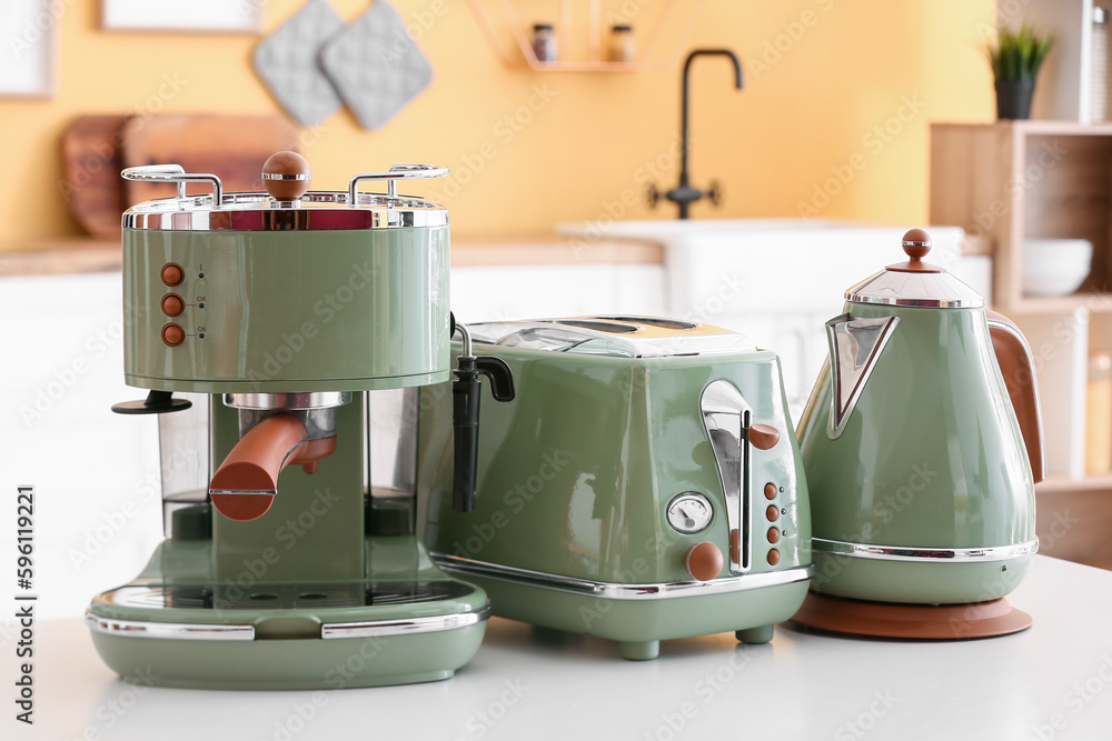 Coffee machine, toaster and electric kettle on table in kitchen