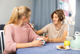 Fototapeta  - Happy family of mother and teenage son enjoying conversation, sitting at kitchen at home