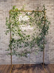 Wedding greenery backdrop with neon sign that’s says better together 