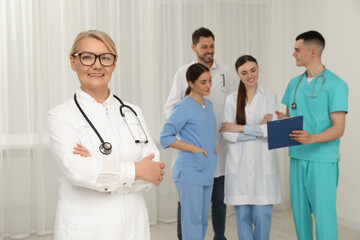 Canvas Print - Portrait of doctor near colleagues in clinic