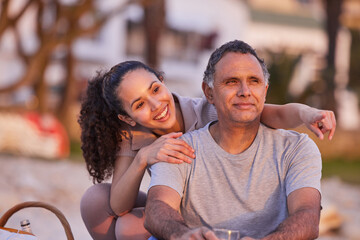 Poster - Its right over there. an attractive young woman sitting with her father and watching the sunset on the beach.