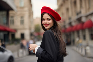 Fashion woman smile with teeth standing on the street in front of the city tourist in stylish clothes with red lips and red beret, travel, cinematic color, retro vintage style, urban fashion.