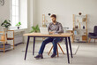 © Studio Romantic - Man working or studying online. Young man sitting at his desk in modern interior at home, using laptop computer, browsing Internet, writing business emails, or studying new educational course