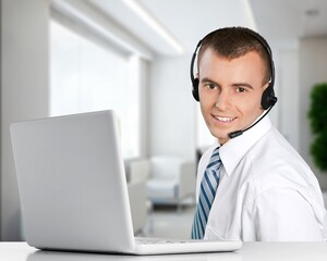 Sticker - Technical support worker with a headset in modern office.