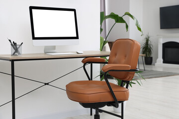 Canvas Print - Comfortable office chair near desk and houseplants in modern workplace