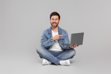 Canvas Print - Happy man with laptop on light grey background