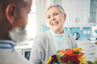 © Azeemud-Deen Jacobs/peopleimages.com - Love, gift and senior couple with flowers, smile and loving at home, bonding and romance. Romantic, man and woman with floral present, celebrate anniversary and relationship with joy and quality time