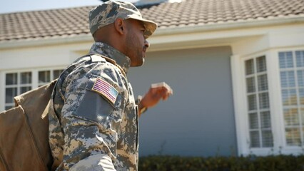 Poster - Patriotic American soldier returns home from military deployment, carrying a backpack and dressed in camouflage clothing